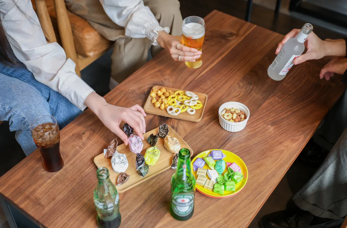 テーブルに広げられたスナックをつまむ人々