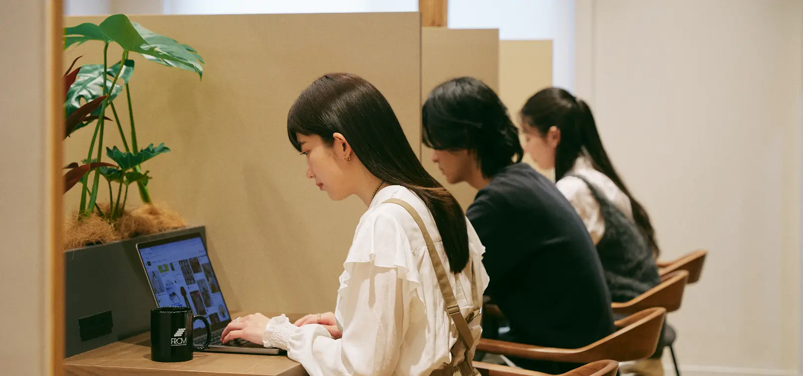 ブースでPC作業する女性